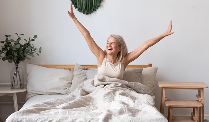 Glückliche Frau streckt sich im Bett Glückliche Frau streckt sich im Bett